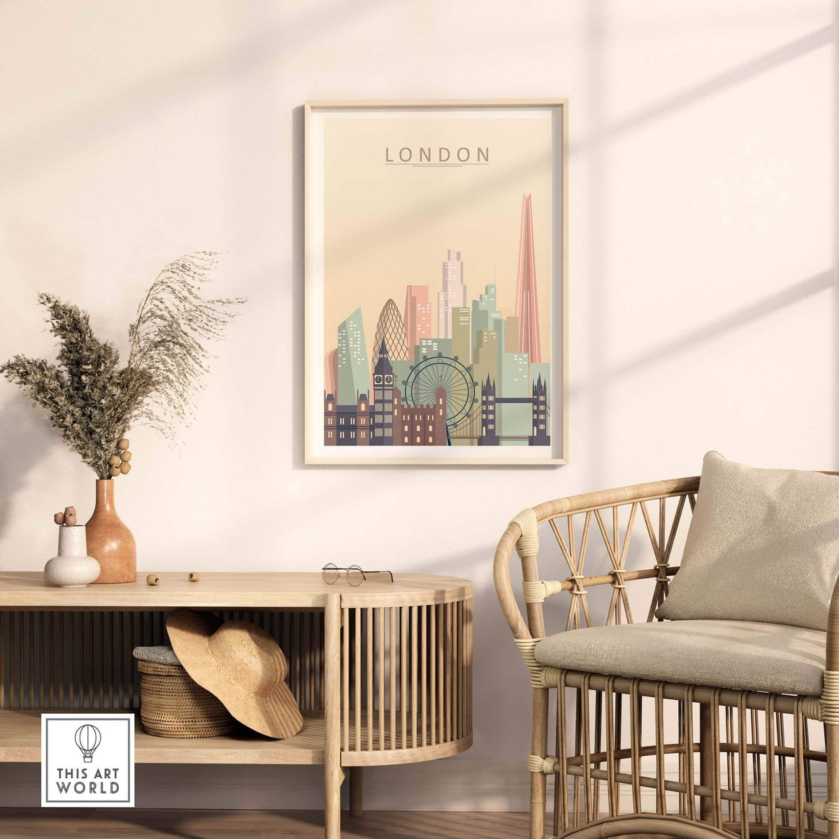 London skyline print in warm pastel tones framed on a wall above a wooden table with a plant and a straw hat.