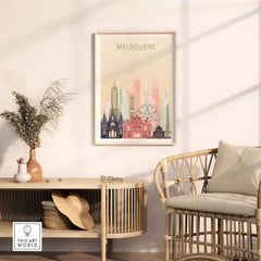 Melbourne skyline print in pastel tones displayed on a wall above a stylish rattan chair and table.