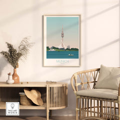 Munich travel poster artwork framed on a wall, showcasing the iconic TV tower and serene water view.